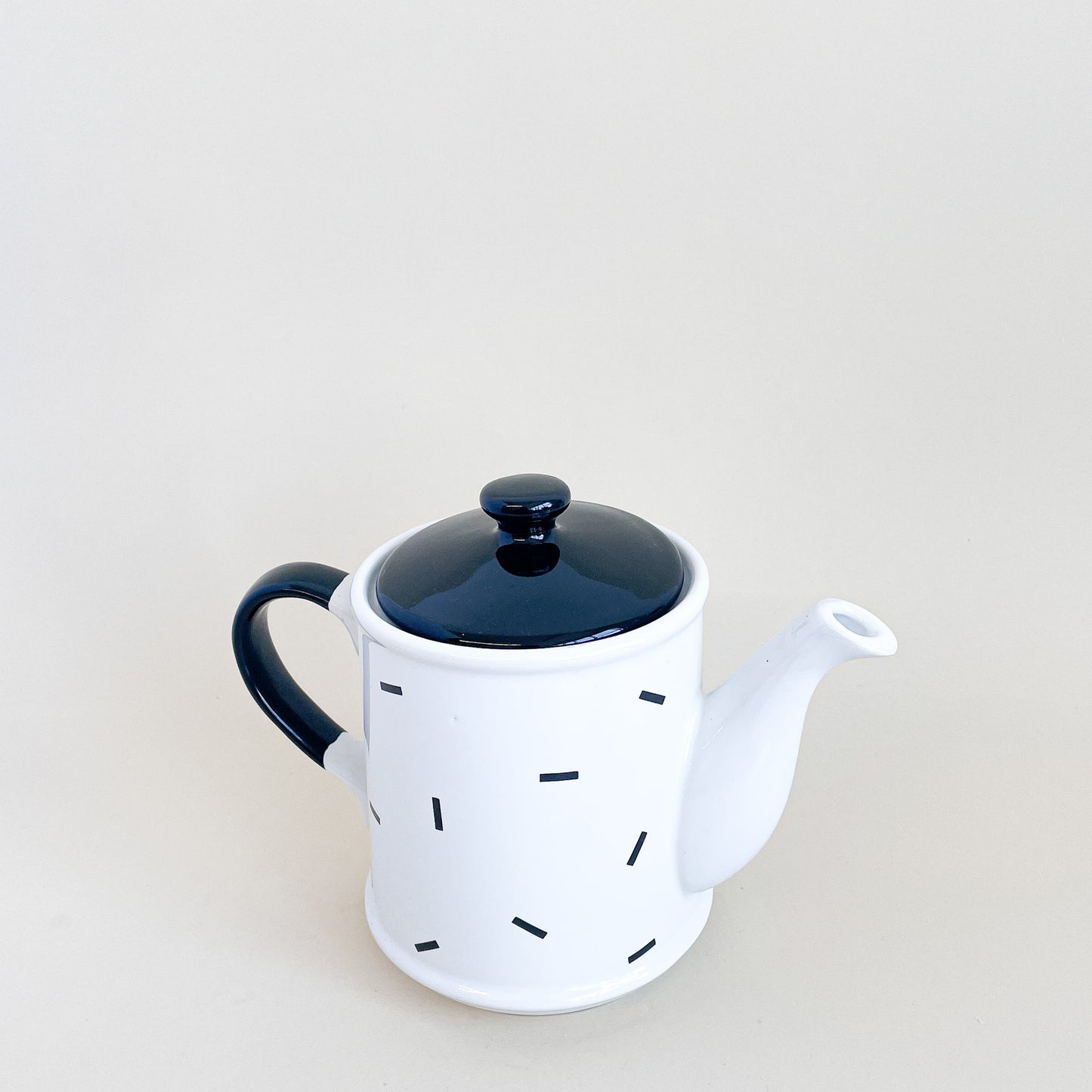 White teapot with black confetti