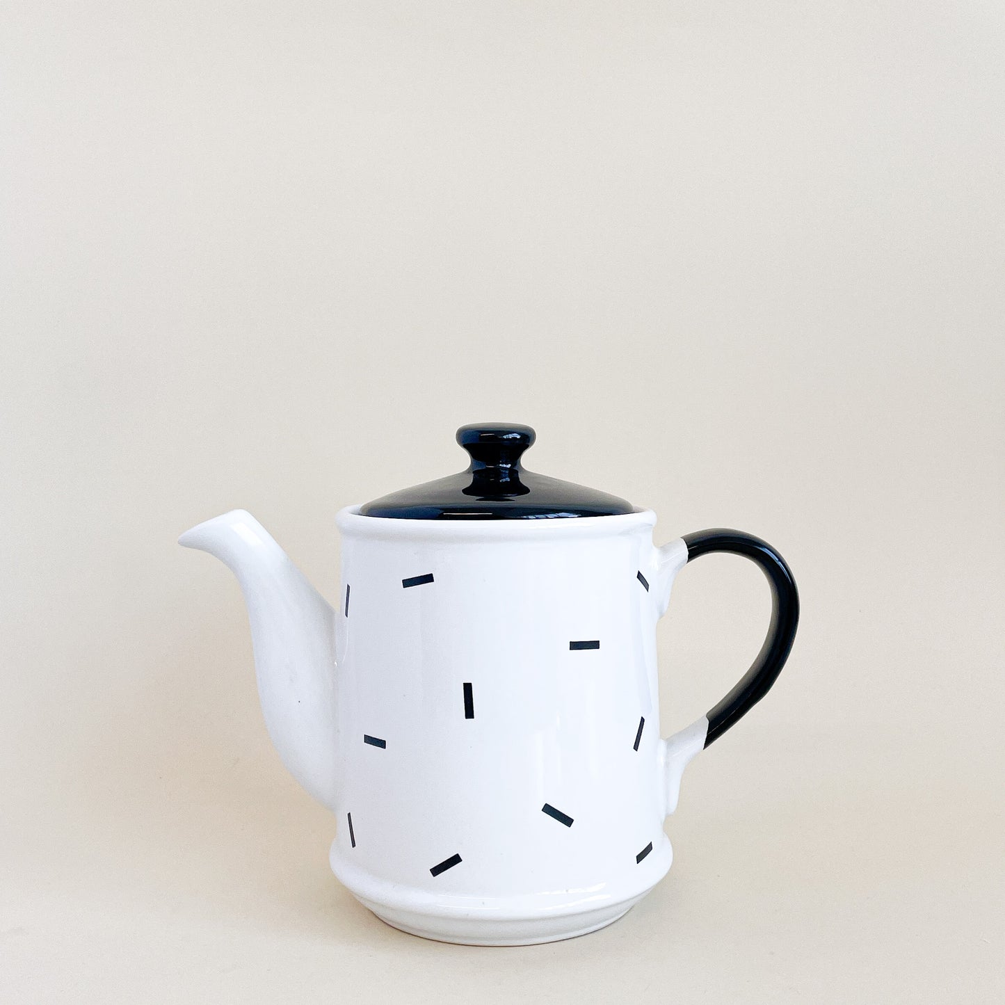 White teapot with black confetti