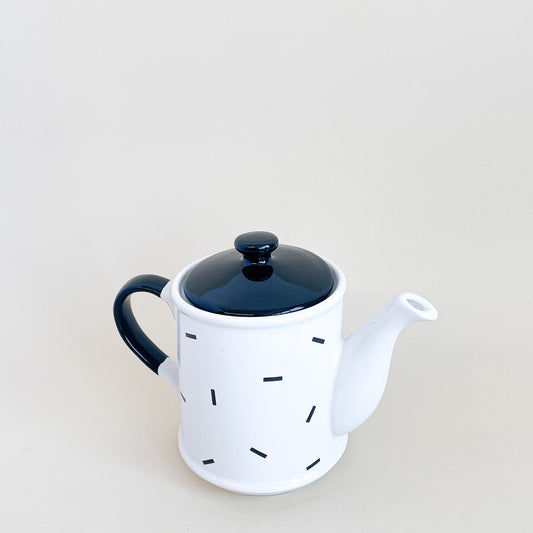 White teapot with black confetti