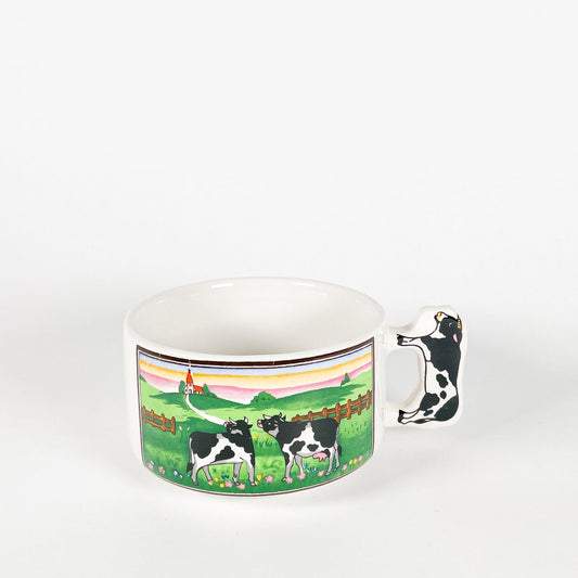 Tasse vaches qui regardent vers une maison