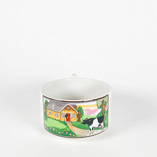 Cow in front of a house mug